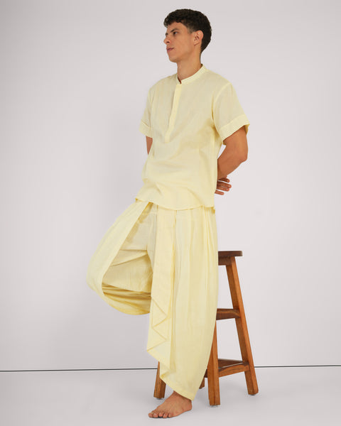 Chaand yoga set in soft cotton, styled for relaxed mindful movement. Male model sitting in brown stool with white background.